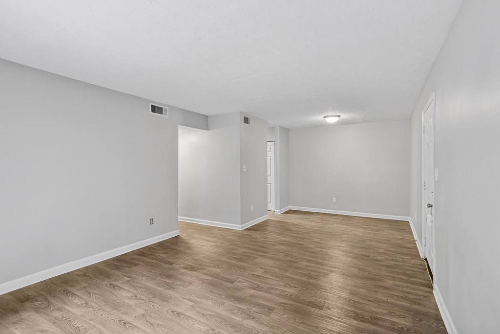 A room with wooden flooring and white walls.
