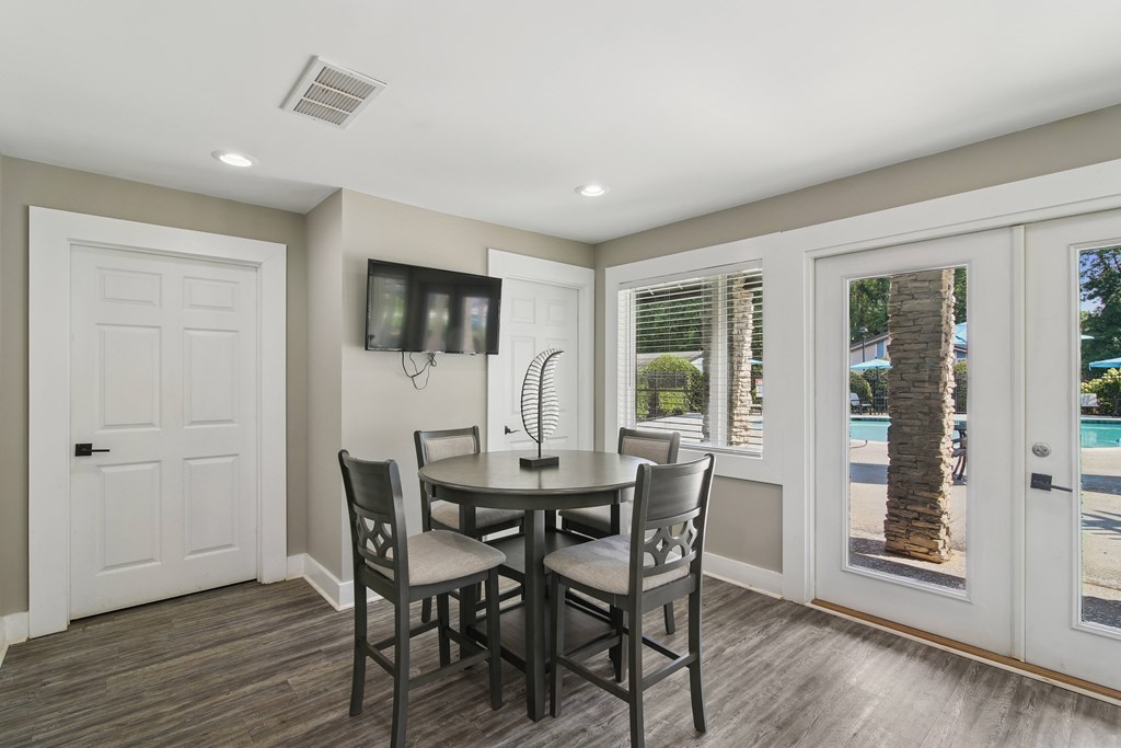 A dining room with a table and chairs.