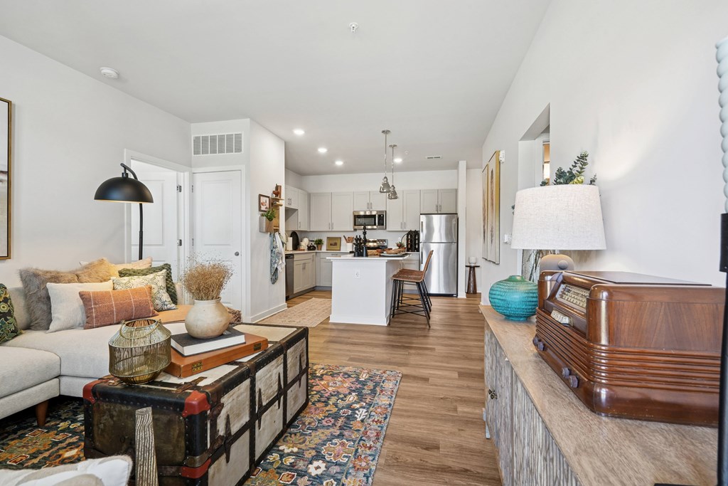 A living room with a white couch and a coffee table with a vase on it.