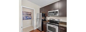 A kitchen with a refrigerator, oven, and microwave.