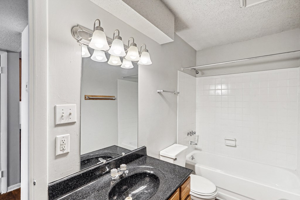 a bathroom with a sink and a mirror and a tub