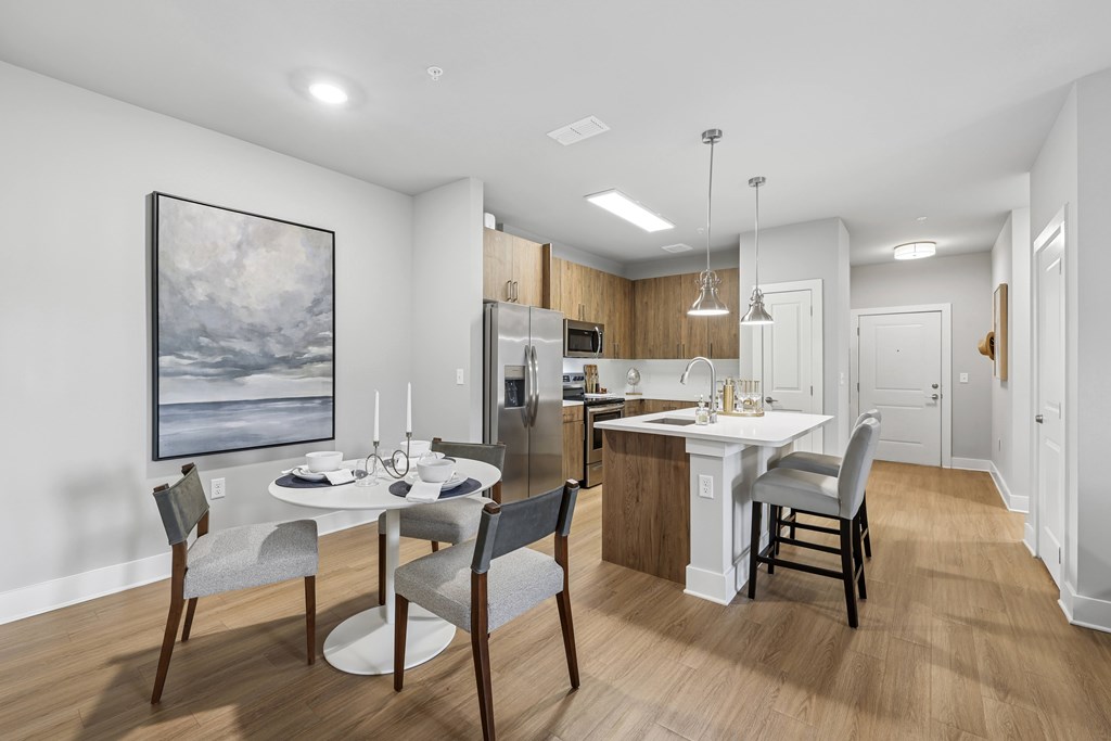 A modern kitchen with a dining table set for four.at The Exchange at Crestview Apartments, Crestview, FL, 32536