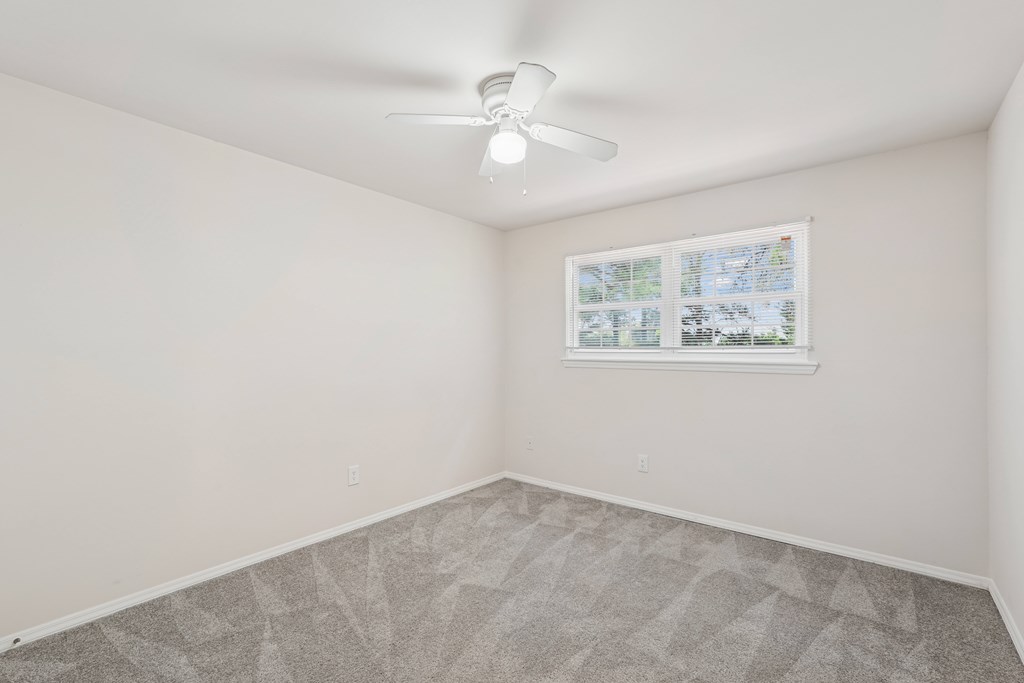 A room with a ceiling fan and a window with a view of a map.