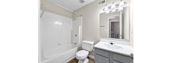 A white bathroom with a toilet, sink, and bathtub.