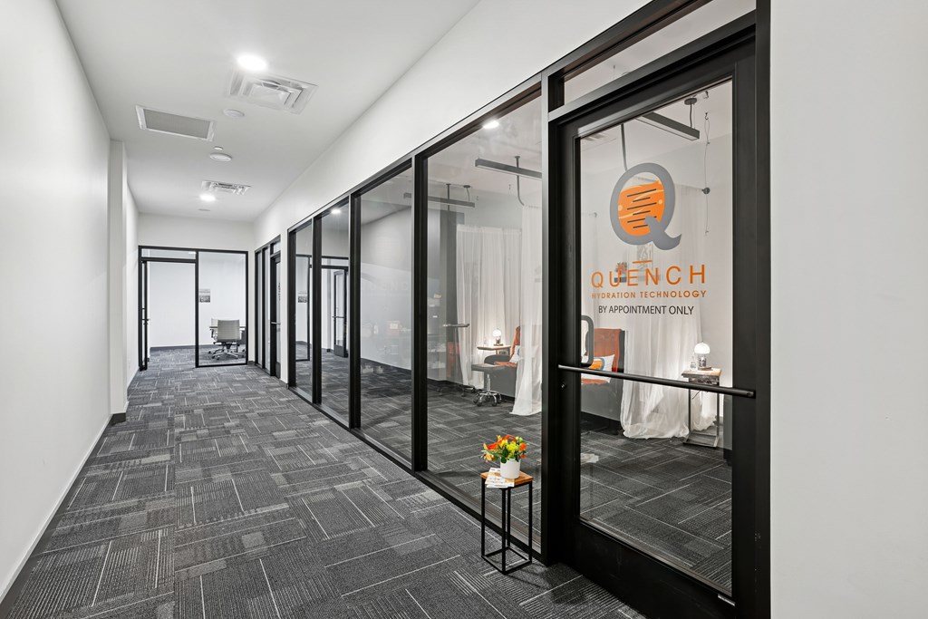 A hallway with a glass door and a sign that says "Quench".
