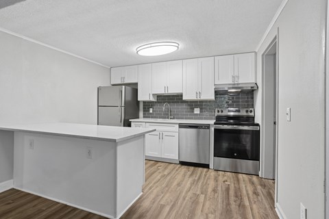A kitchen with white cabinets and stainless steel appliances.
