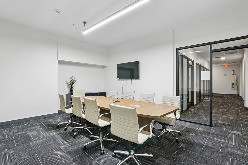 A conference room with a long table and chairs.
