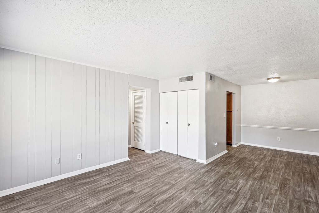 an empty living room with white walls and wood floors