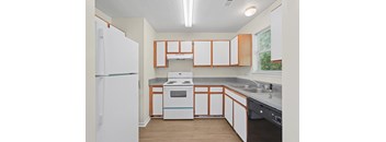 A kitchen with a white refrigerator and wooden cabinets.