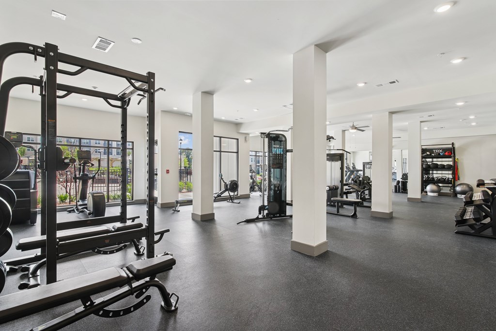 A gym with a variety of equipment including weights and cardio machines.at The Delaney at East Park Apartments, Kennesaw