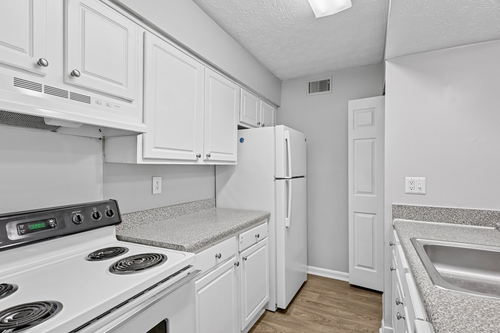 A kitchen with white cabinets and appliances.