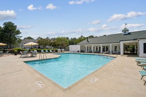 A large swimming pool with a building in the background.