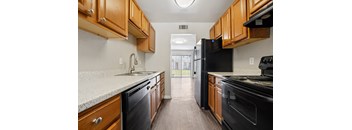 A kitchen with black appliances and wooden cabinets.