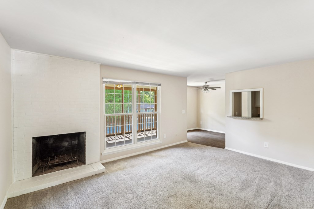 an empty living room with a fireplace and a window