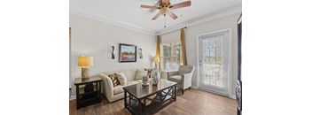 A living room with a white couch, a coffee table, and a ceiling fan.
