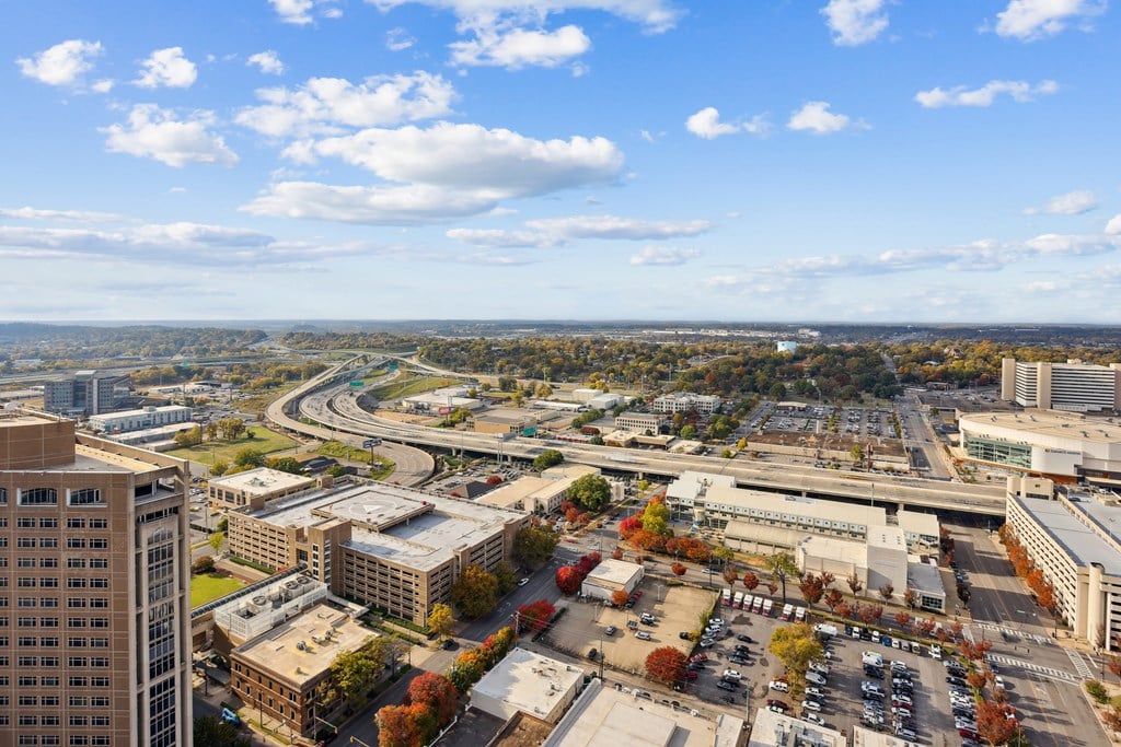 A cityscape with a clear blue sky and a highway in the distance.