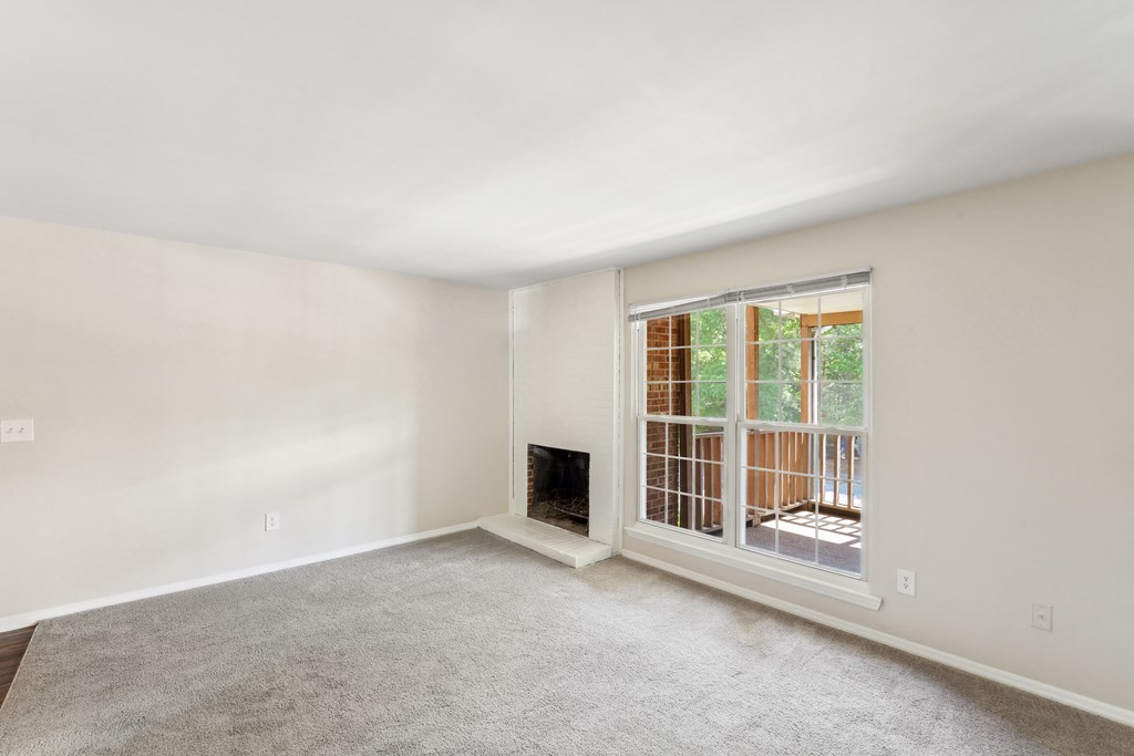 a living room with a fireplace and a large window