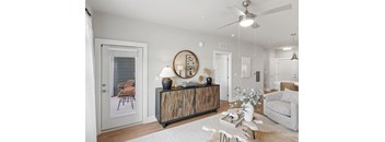 A modern living room with a wooden cabinet and a grey sofa.