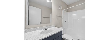 A bathroom with a sink, toilet, and shower.