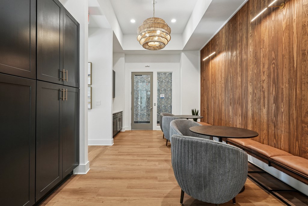 A long hallway with a bench and chairs on the right side.