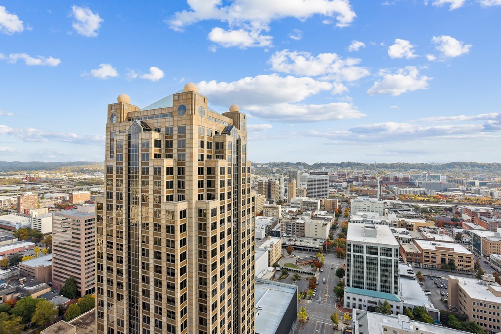 A tall building with many windows stands in the foreground of a cityscape.