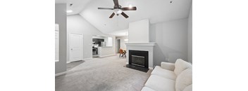A living room with a fireplace and a ceiling fan.