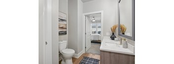 A bathroom with a toilet, sink, and mirror.