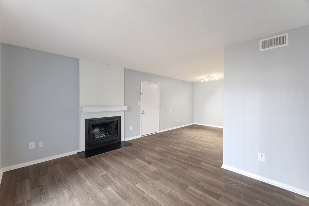a living room with a fireplace and wooden floors  at Governors House, Huntsville, Alabama