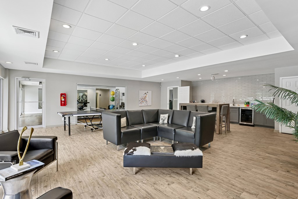 A modern living room with a grey sofa set and a wooden floor.