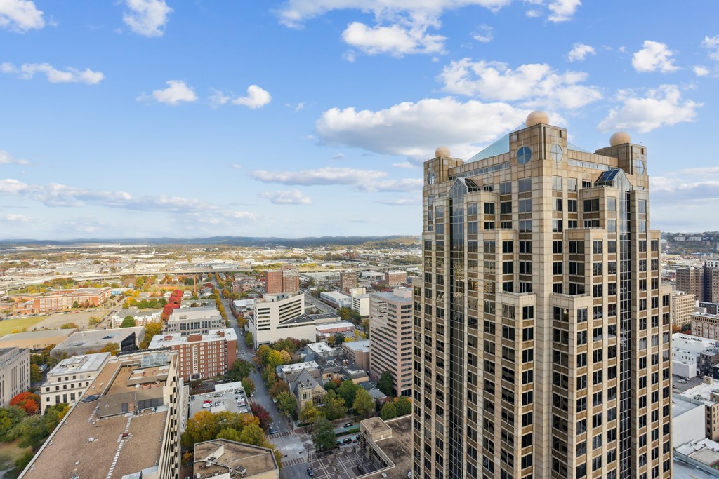 A tall building stands in the foreground of a cityscape.