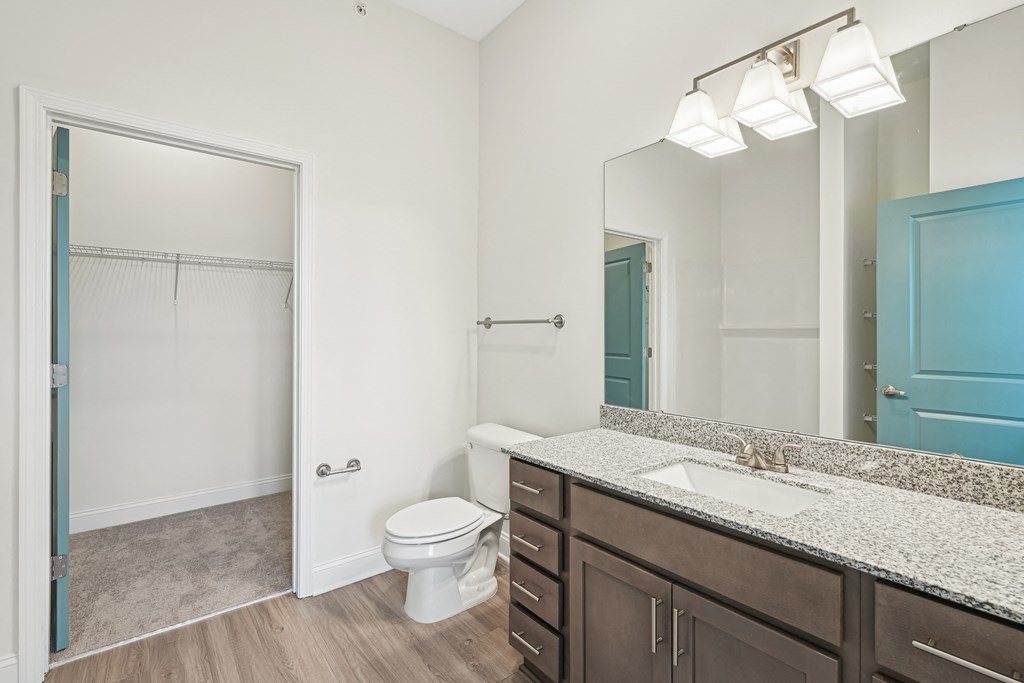 A bathroom with a toilet, sink, and mirror.at The Parker Leland, North Carolina, 28451 