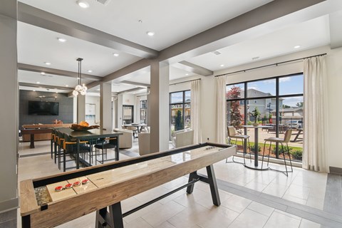 A modern dining room with a long wooden table and chairs.