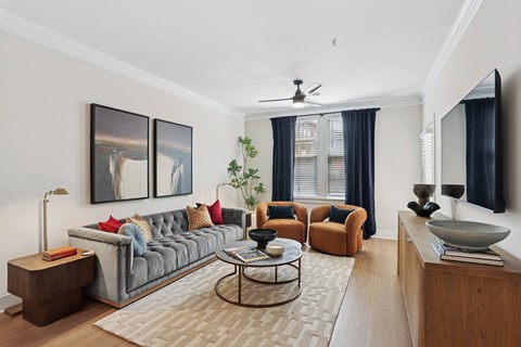 A living room with a grey couch, a coffee table, and a painting on the wall at Union Eleven Apartments, Atlanta, Georgia