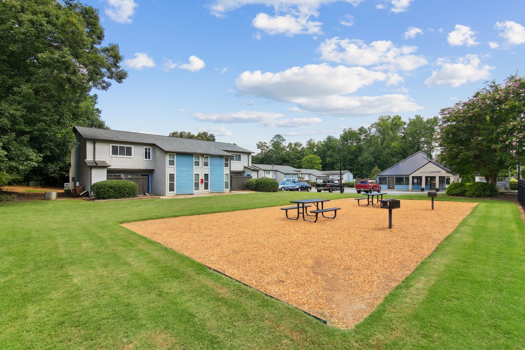 A park with a playground and picnic tables.