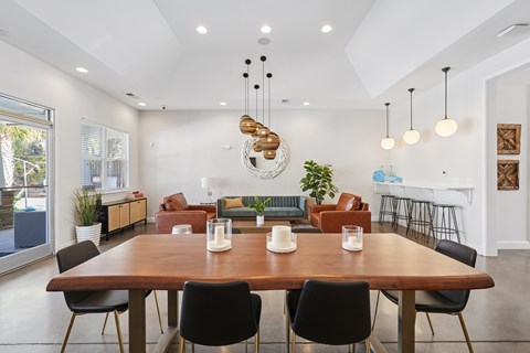 A modern dining room with a large wooden table and chairs.
