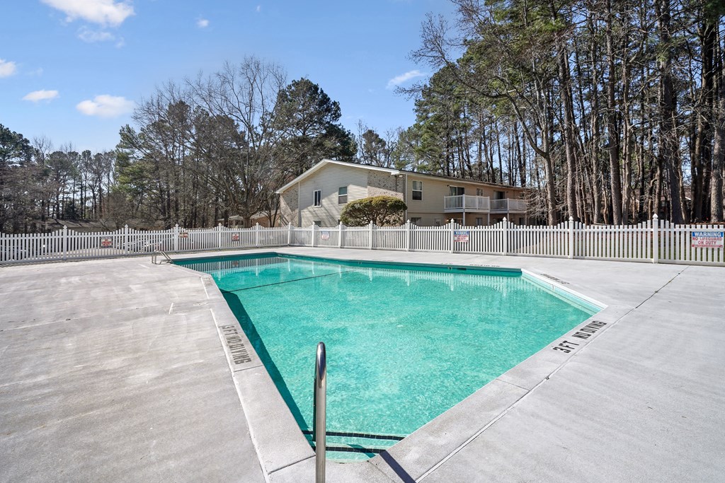 a swimming pool with a house in the background