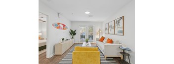 A living room with a yellow chair and a white couch.