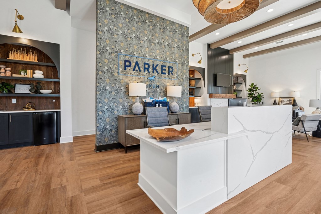 A reception area with a white counter and a wall with a patterned design.