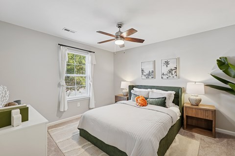 A bedroom with a large bed and a ceiling fan.