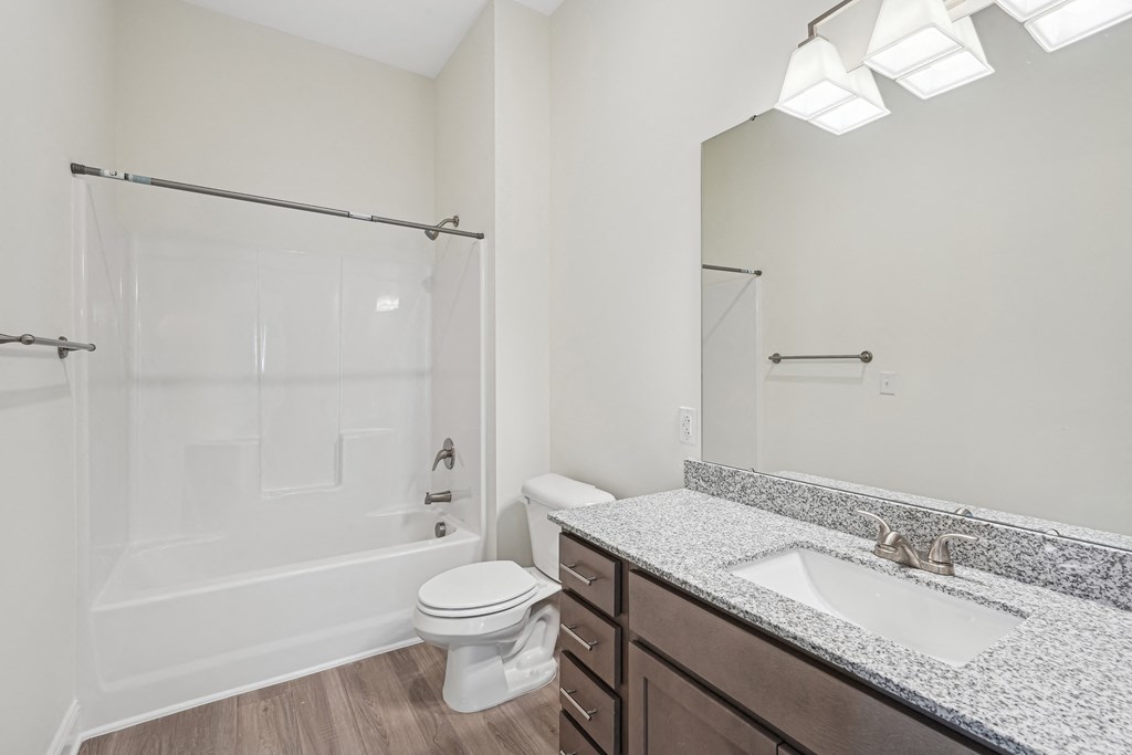 A white bathroom with a toilet, sink, and shower.at The Parker Leland, North Carolina, 28451 