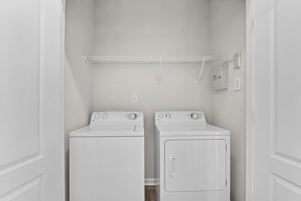 A white laundry room with a washer and dryer.