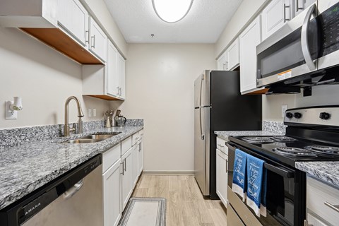 A kitchen with black appliances and white cabinets.