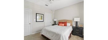 A bedroom with a bed, nightstand, and lamp.