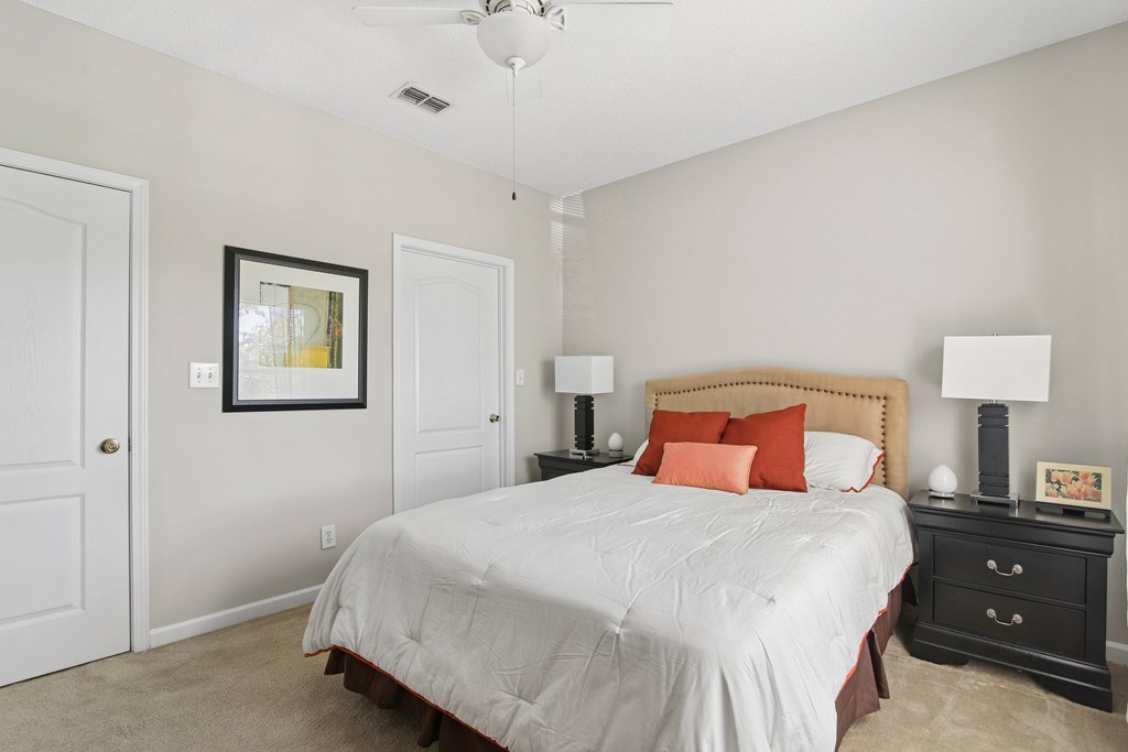 A bedroom with a bed, nightstand, and lamp.