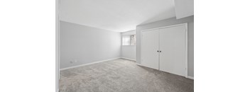 A room with a carpeted floor and a white door.
