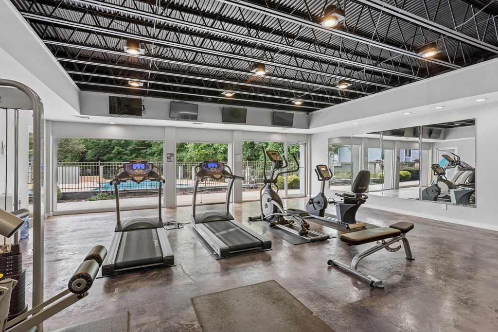 A gym with treadmills, exercise bikes, and other equipment.