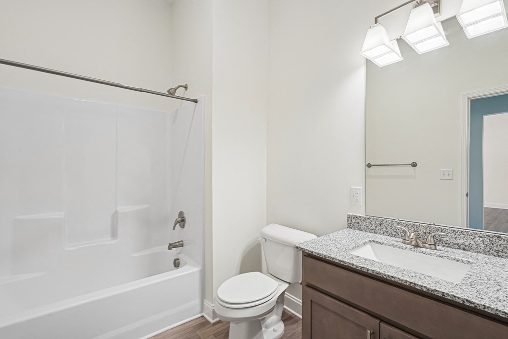 A white toilet sits next to a sink in a bathroom.at The Parker Leland, Leland North Carolina  