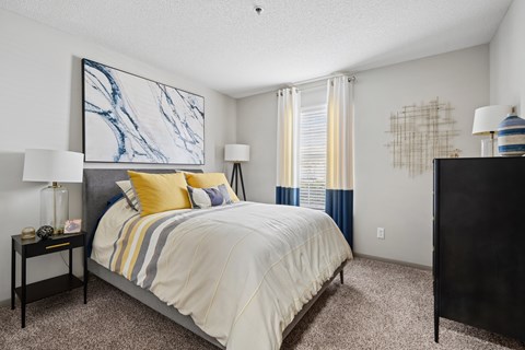 A bedroom with a large bed and a painting on the wall.