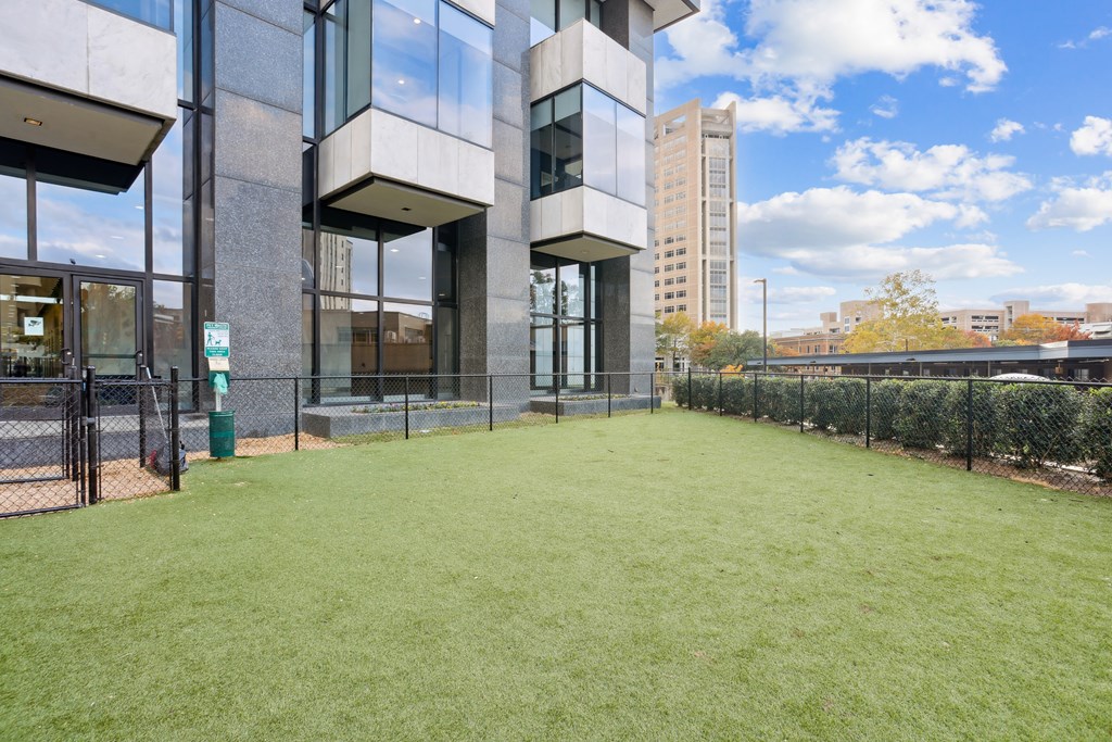 A large grassy area in front of a modern building.