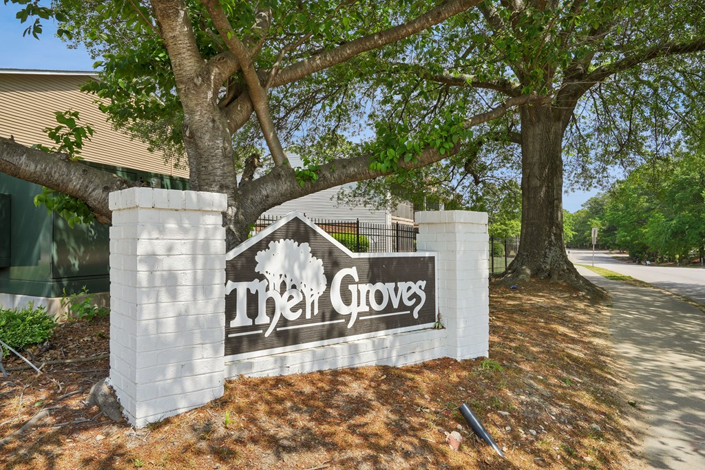 the sign at the entrance of the groves apartments